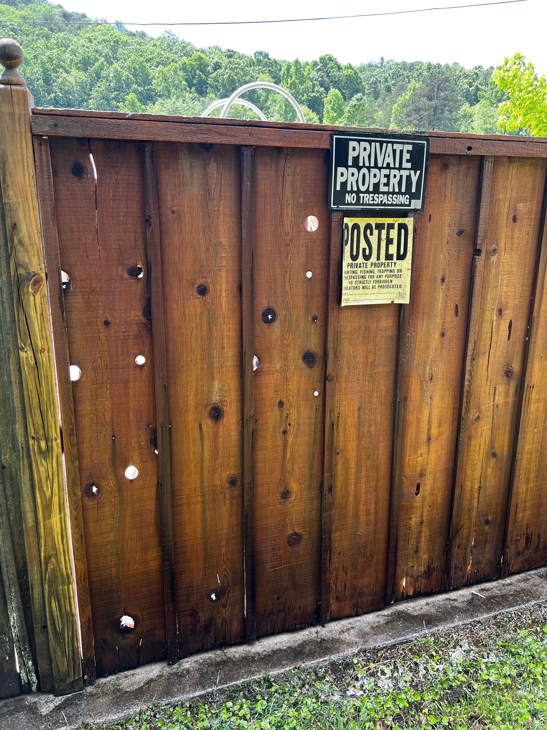 A wooden fence with a sign on it that says private property. Job done by 865 Power Wash