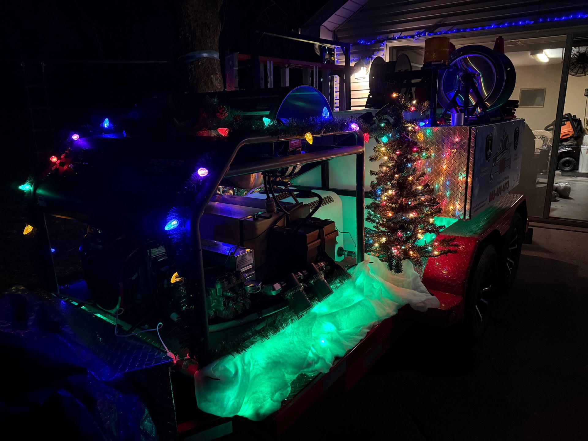 A trailer is decorated with christmas lights and a christmas tree.
