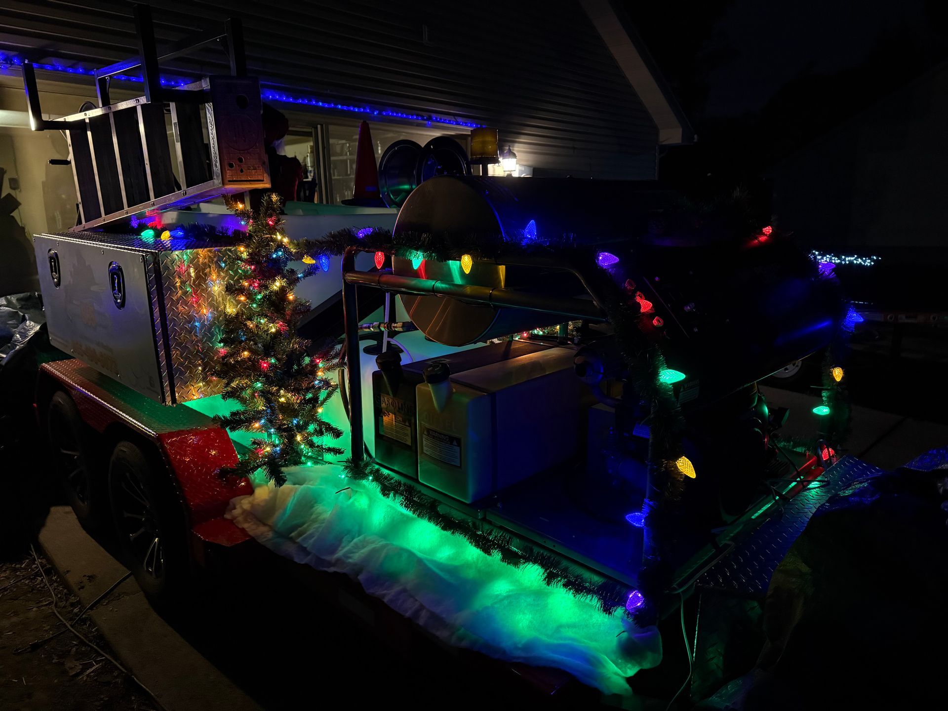 A truck is decorated with christmas lights and a christmas tree.