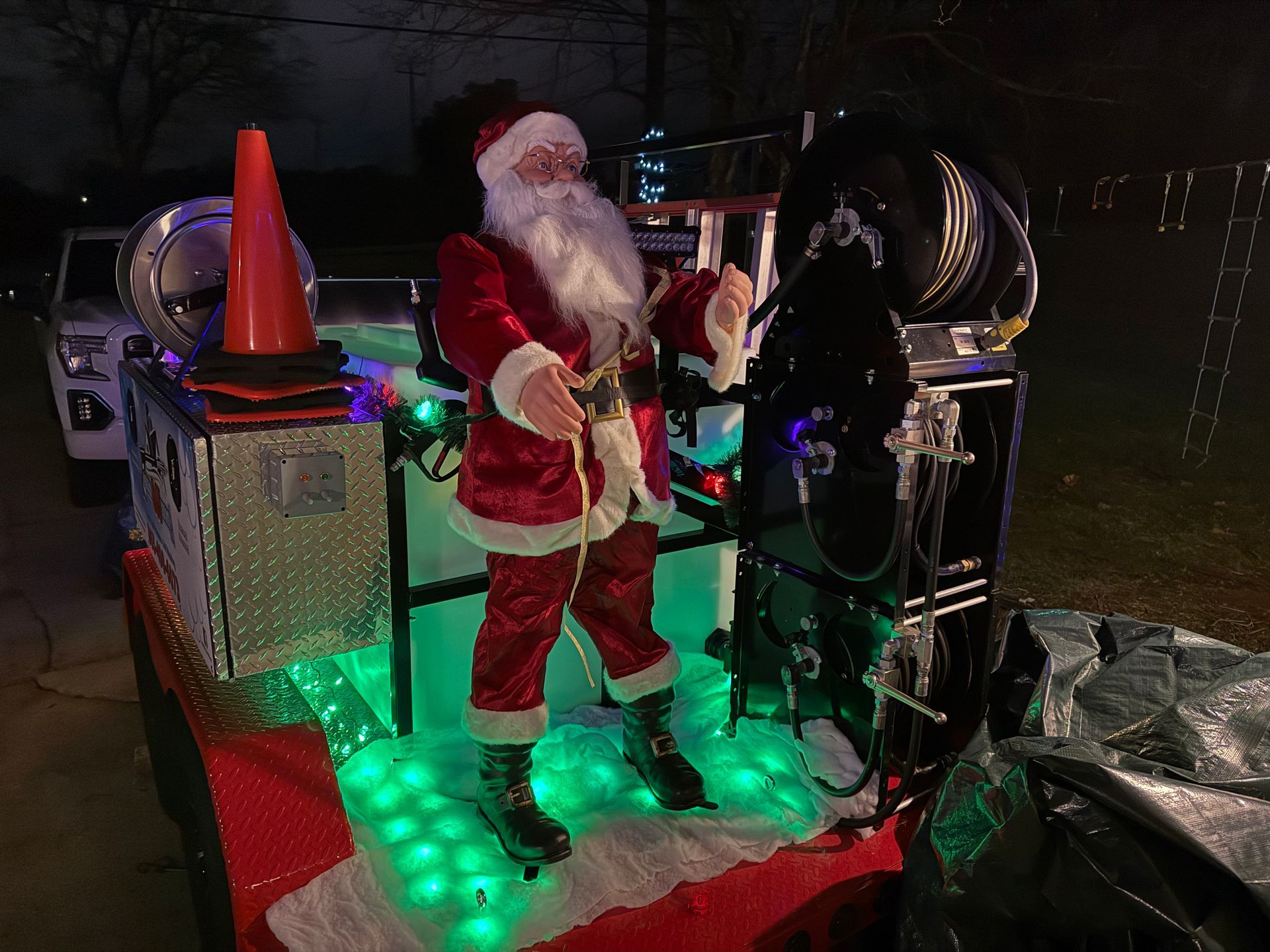 A statue of santa claus is standing on top of a christmas float.