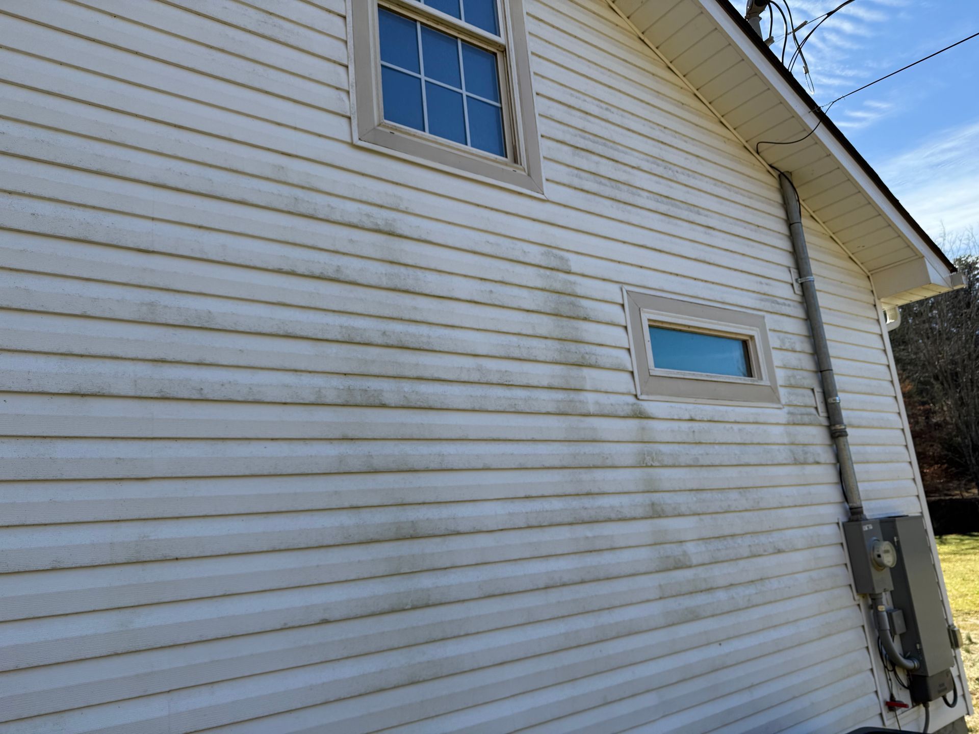 A white house with a lot of stains on the side of it. Job done by 865 Power Wash