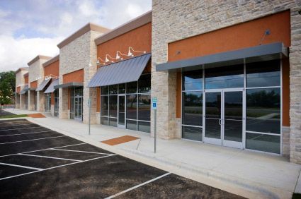 A row of commercial buildings with a parking lot in front of them
