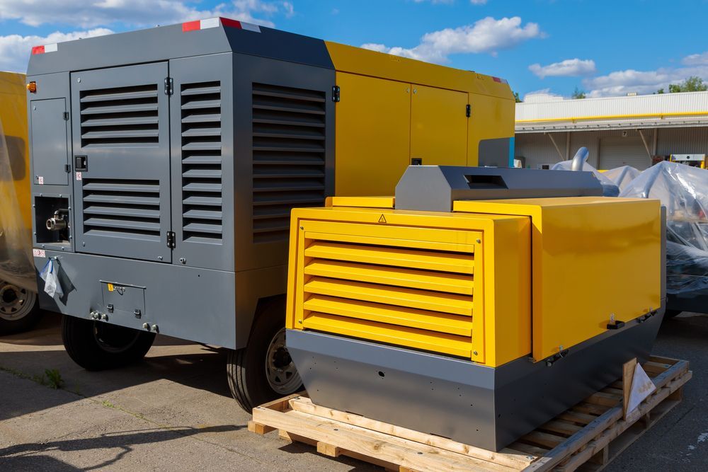 A Yellow and Gray Air Compressor is Sitting on a Wooden Pallet — Davidson's Electrical In Central Highlands, QLD