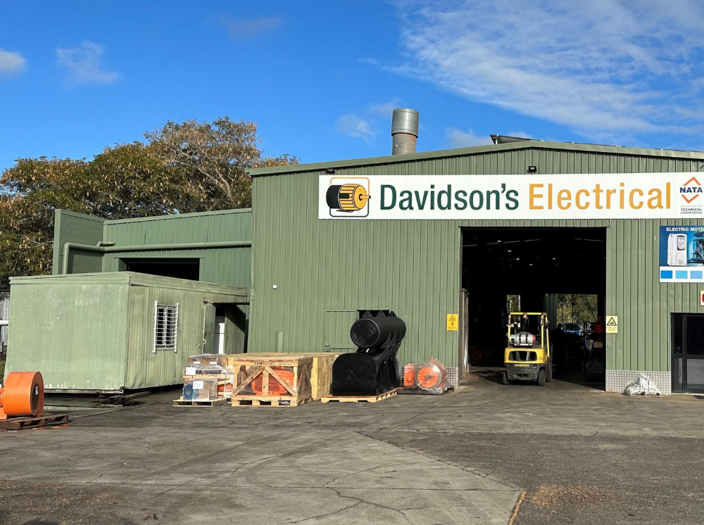 A Generator is Sitting in the Grass in Front of a House — Davidson's Electrical In Mackay, QLD