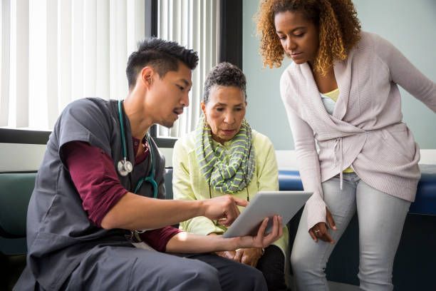 A doctor and a patient are looking at a tablet together.