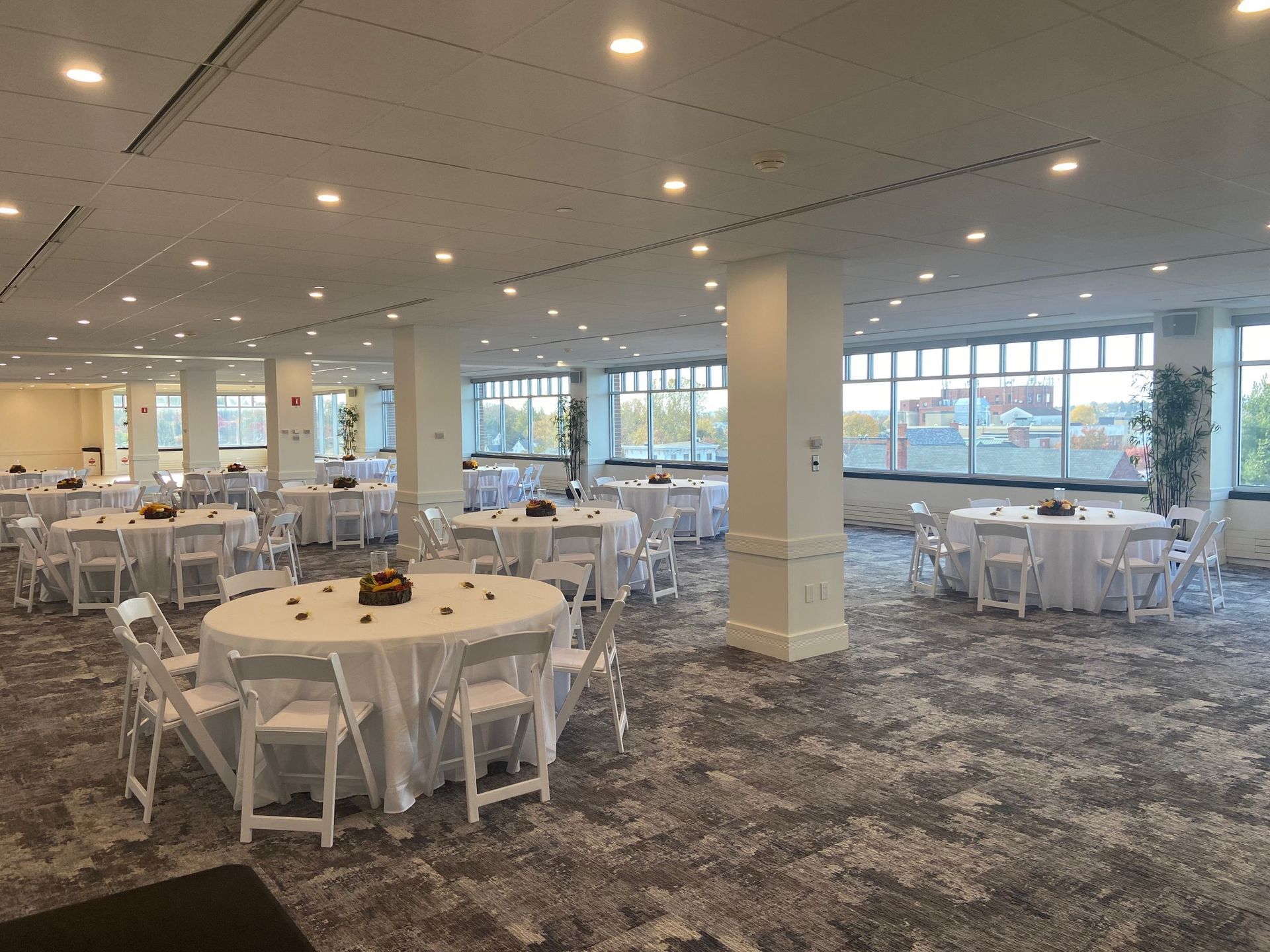 A large room with tables and chairs set up for a wedding reception.