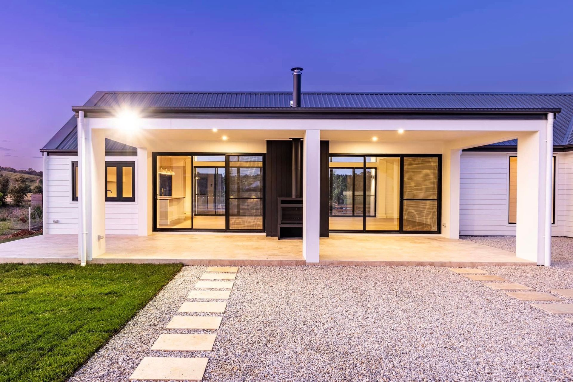 A white house with a large porch and sliding glass doors.
