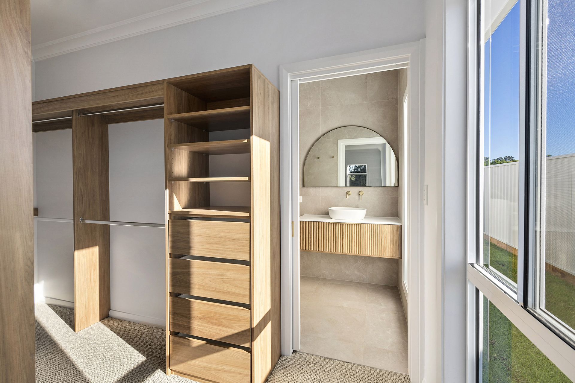 Walk in closet and a bathroom in the background.