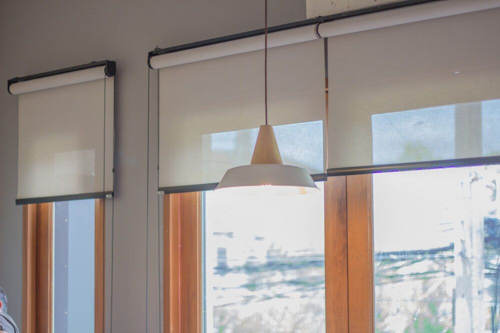 There Are Two Windows With Blinds and a Lamp Hanging From the Ceiling — Lismore Blinds in Ballina, NSW