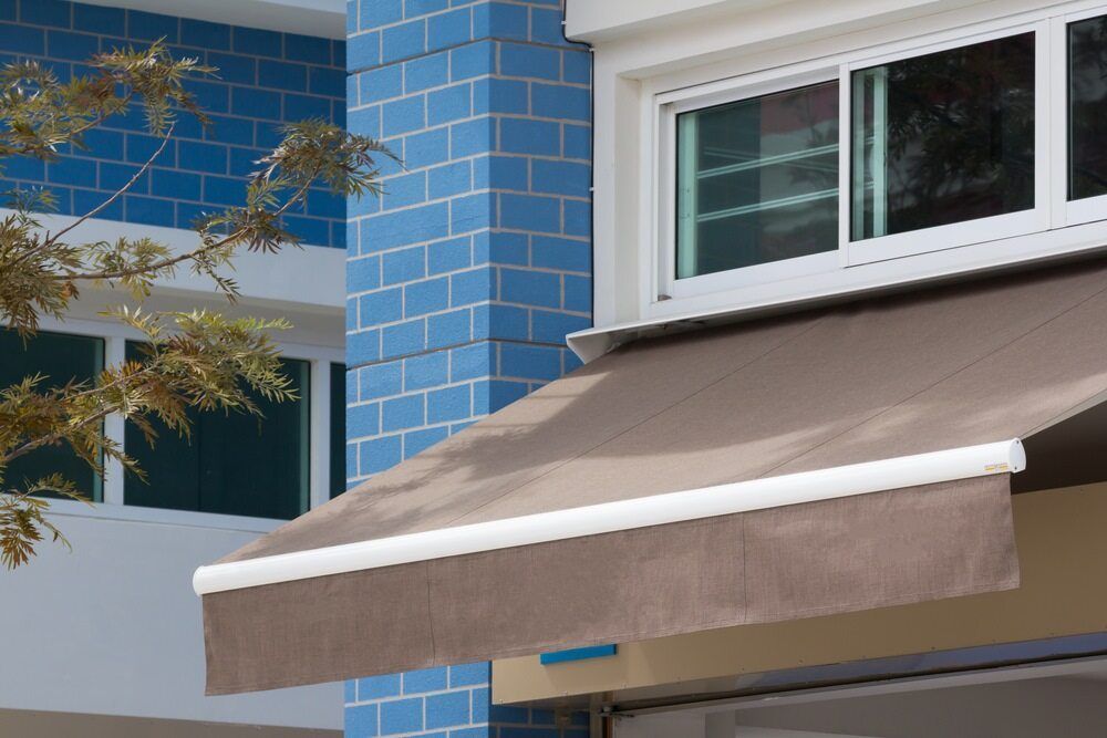 A Brown Awning is on the Side of a Building Next to a Window — Lismore Blinds in North Lismore, NSW