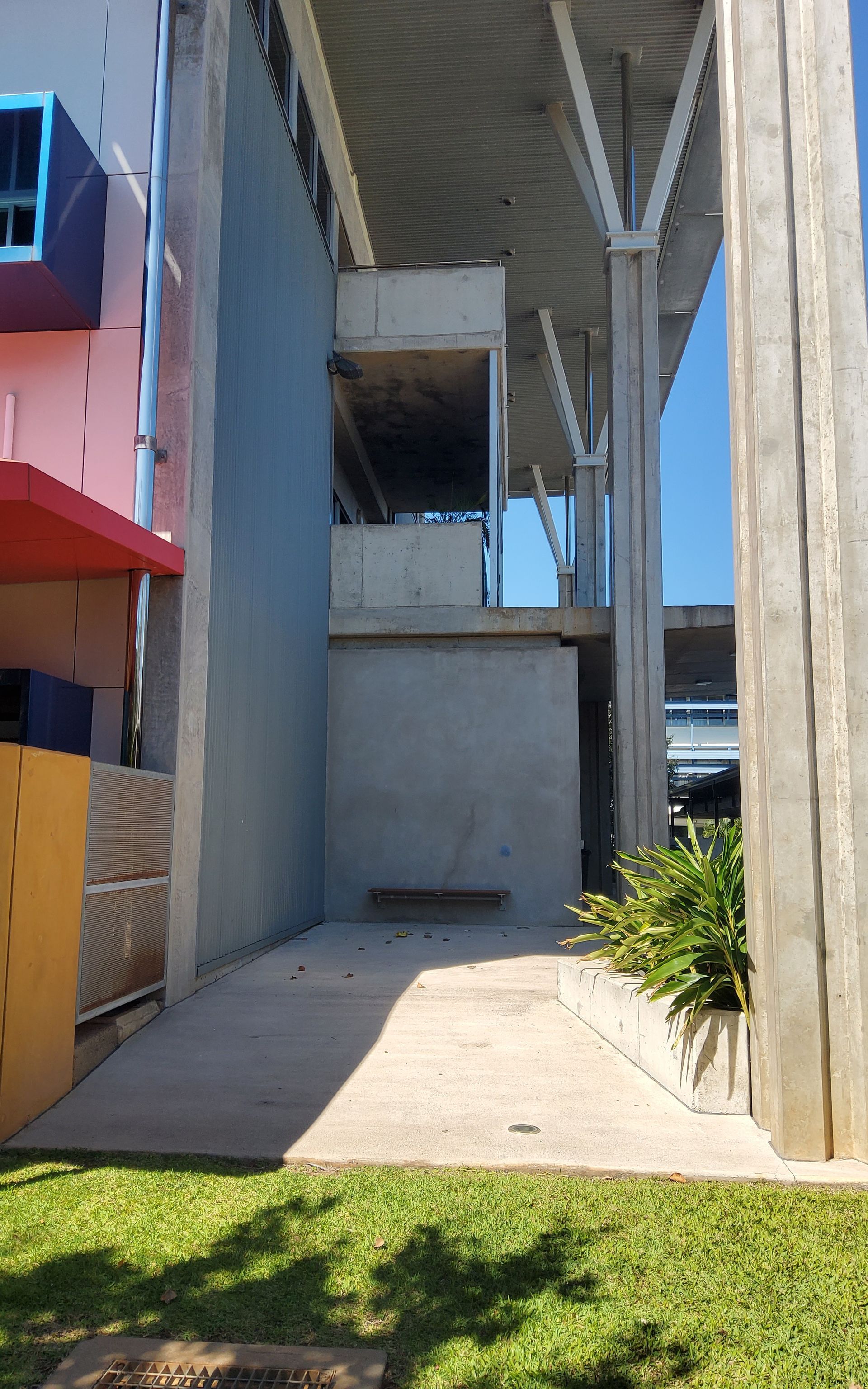 Ramp to Gray Wall with A Bench, Plants, and Large Concrete Support Beams — EXPOSURE NORTH PLASTERING PTY LTD in Berry Springs, NT