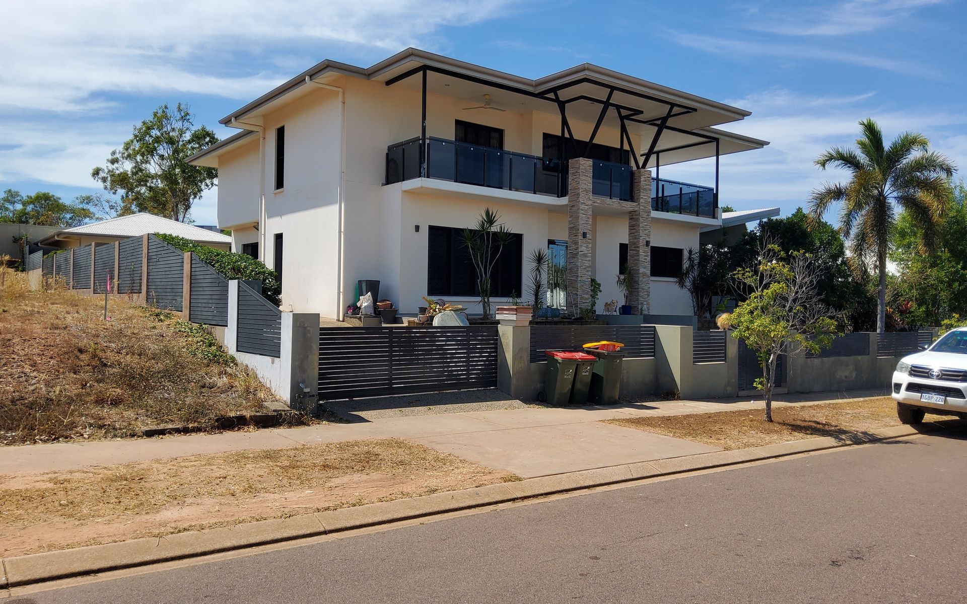 Two-Story White House with Balcony and Modern Design, Near a Gate and Driveway — EXPOSURE NORTH PLASTERING PTY LTD in Berry Springs, NT