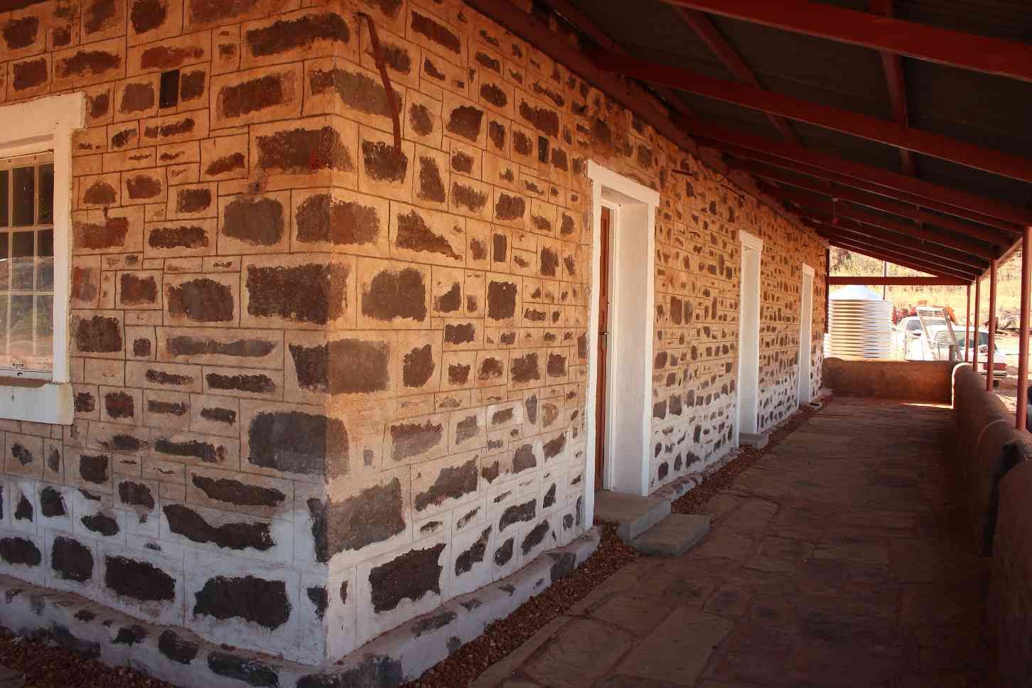 Stone Building With a Covered Walkway, White Doors and Trim — EXPOSURE NORTH PLASTERING PTY LTD in Berry Springs, NT