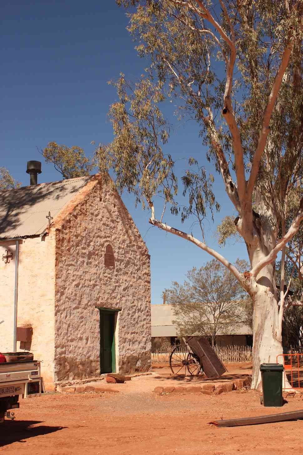 Old Stone Building With Green Door, Tall Tree, Red Dirt, and Blue Sky — EXPOSURE NORTH PLASTERING PTY LTD in Berry Springs, NT