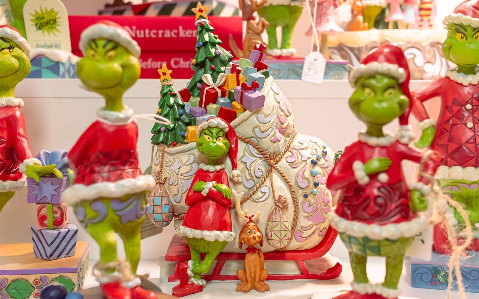 A group of grinch figurines are sitting on a table.
