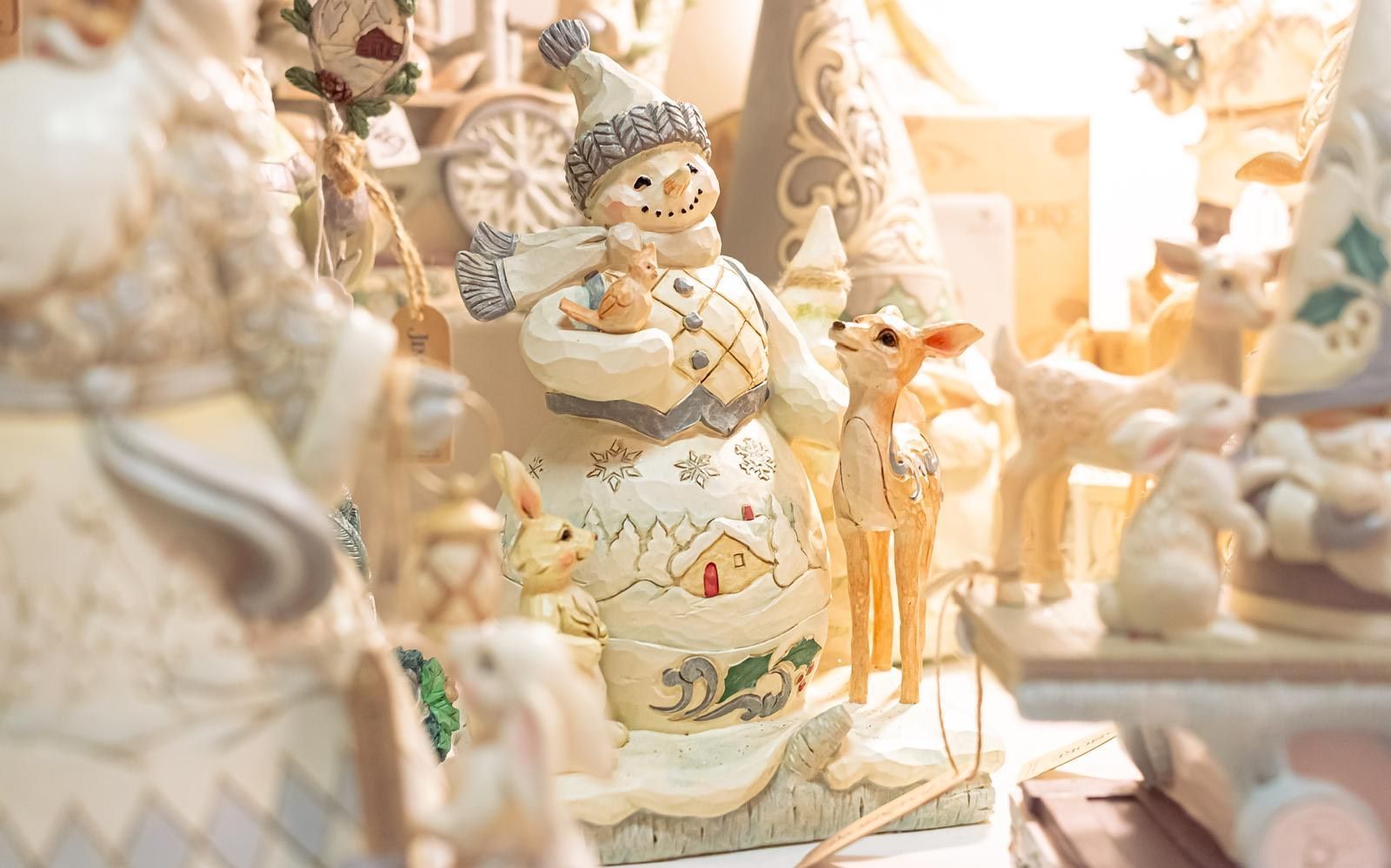 A close up of a statue of a snowman holding a reindeer.