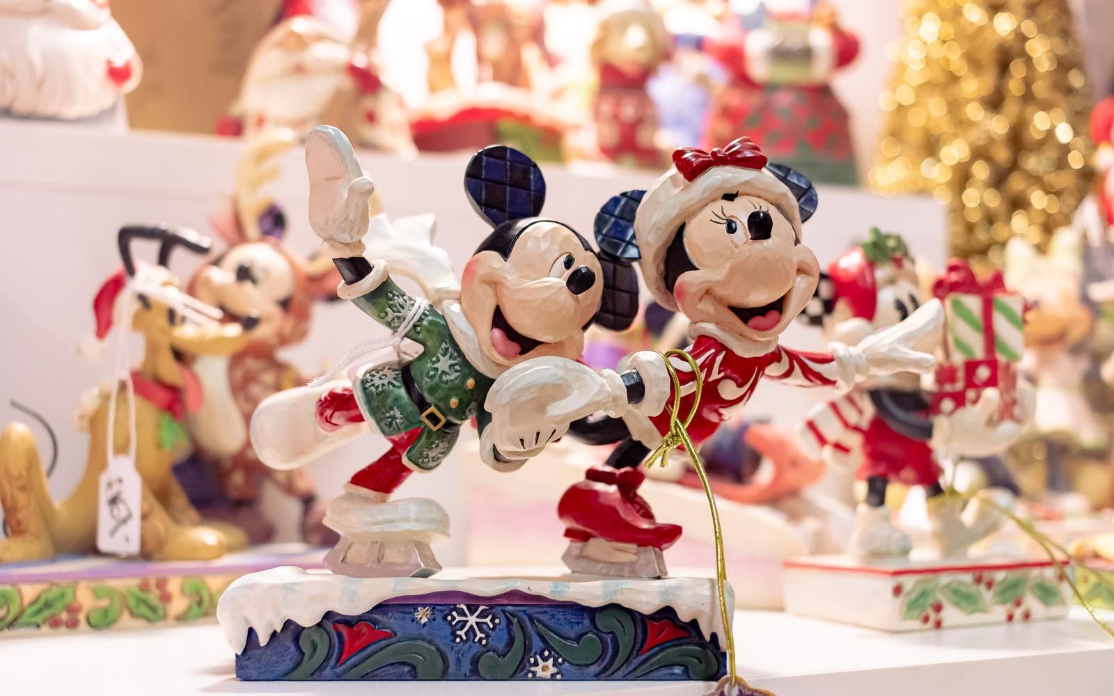 A close up of a figurine of mickey mouse and minnie mouse on a table.