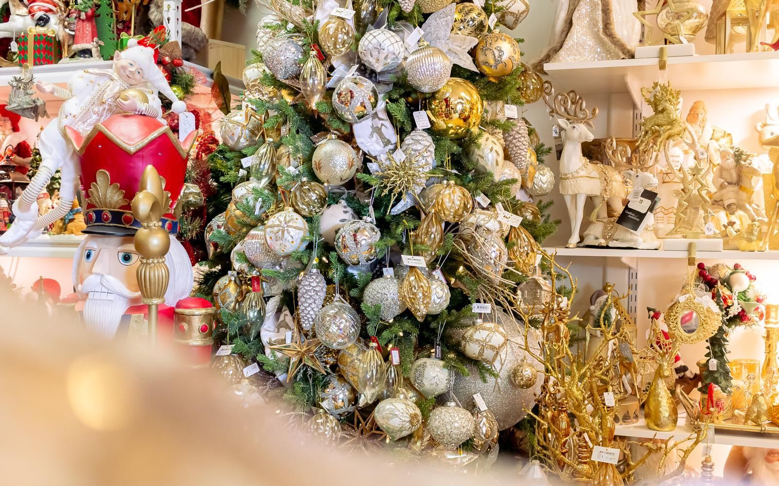 A christmas tree is surrounded by christmas decorations in a store.