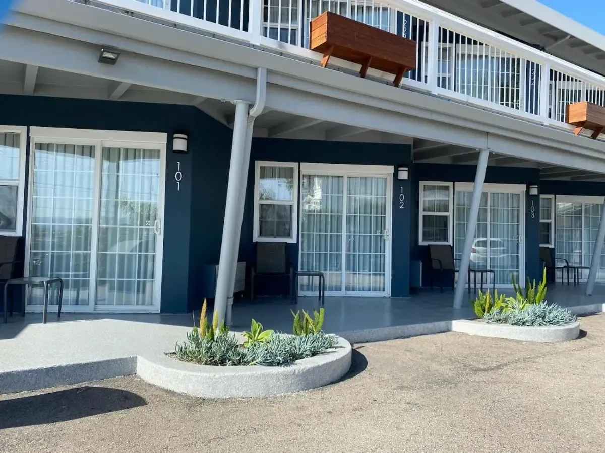 Blue building with white trim, planter boxes and sliding glass doors