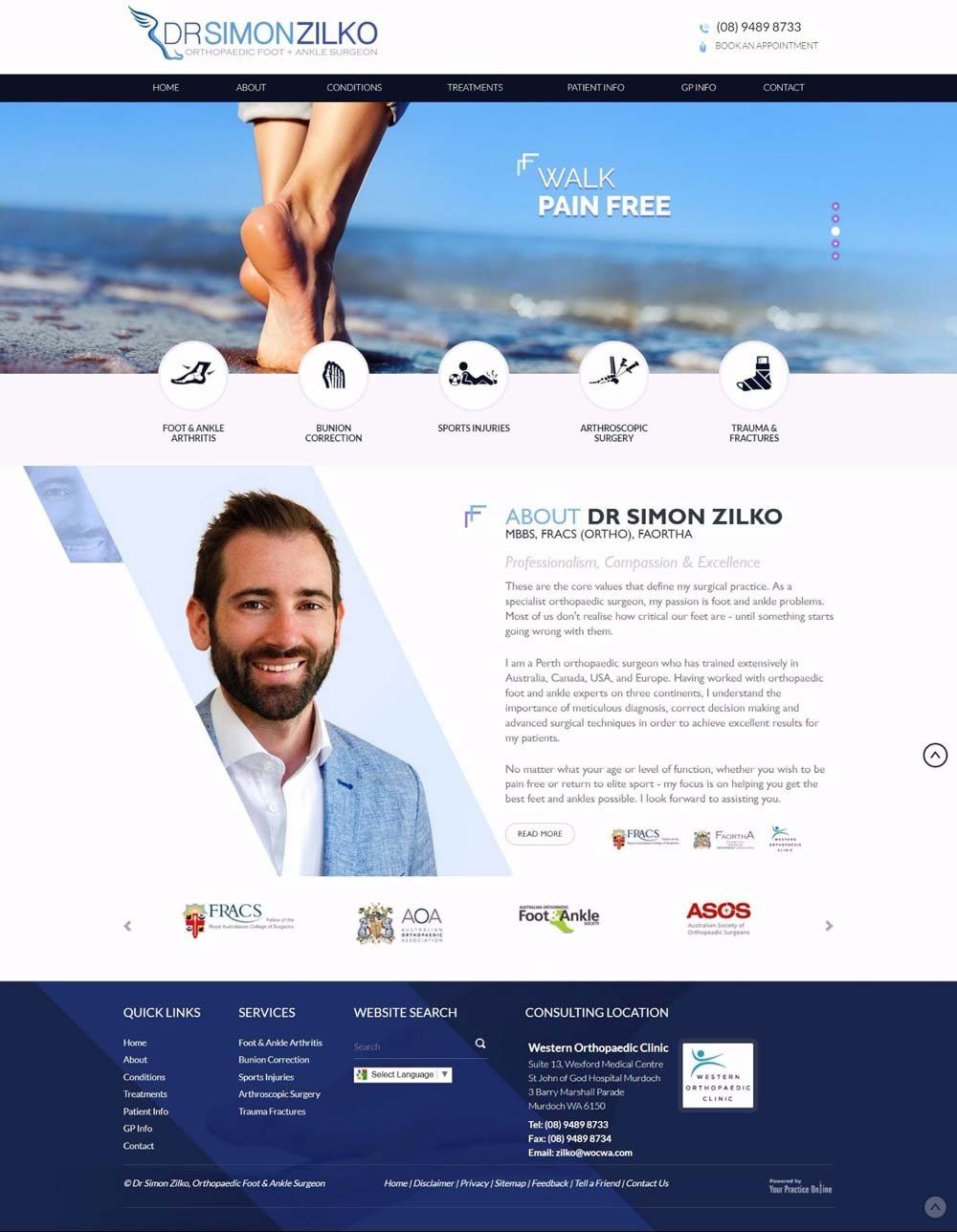 A man with a beard is standing on a beach next to a woman 's feet.