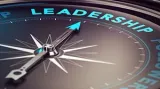 A compass with a teal needle pointing toward the word