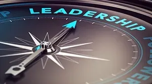 A compass with a teal needle pointing toward the word 