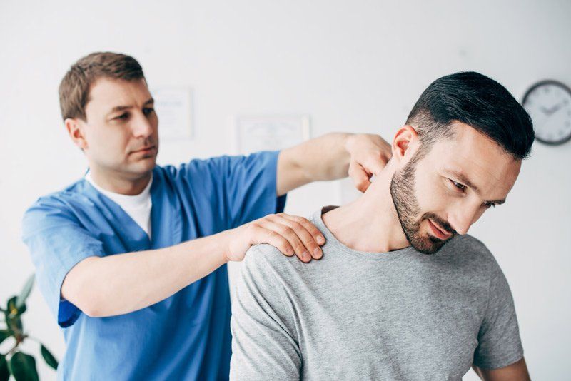 Therapist treating car accident injury patient with physical therapy modalities.
