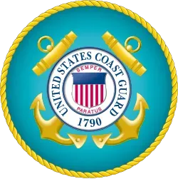 United States Coast Guard seal with gold rope border, crossed anchors, and shield on blue background