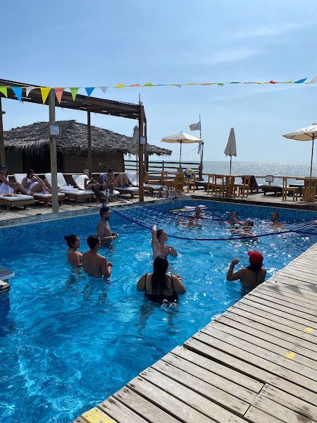 A group of people are playing volleyball in a swimming pool