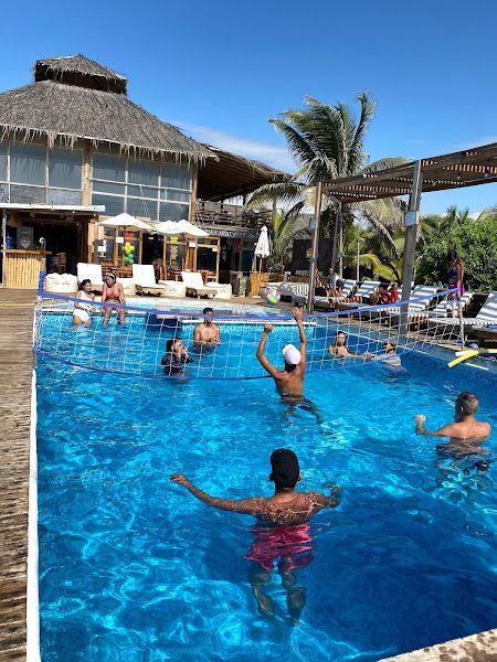 A group of people are playing volleyball in a swimming pool