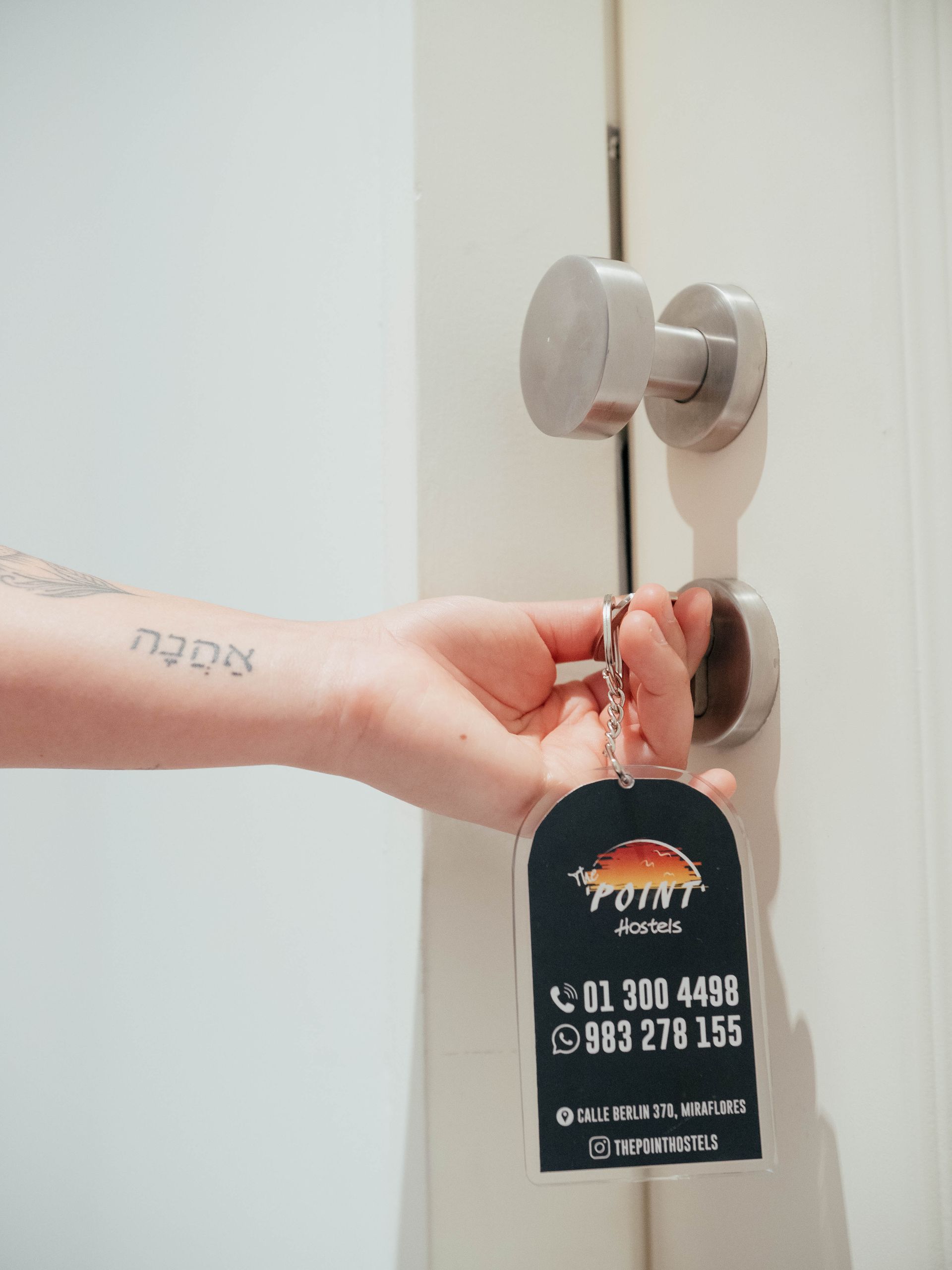 A person with a tattoo on their arm is holding a key in their hand.