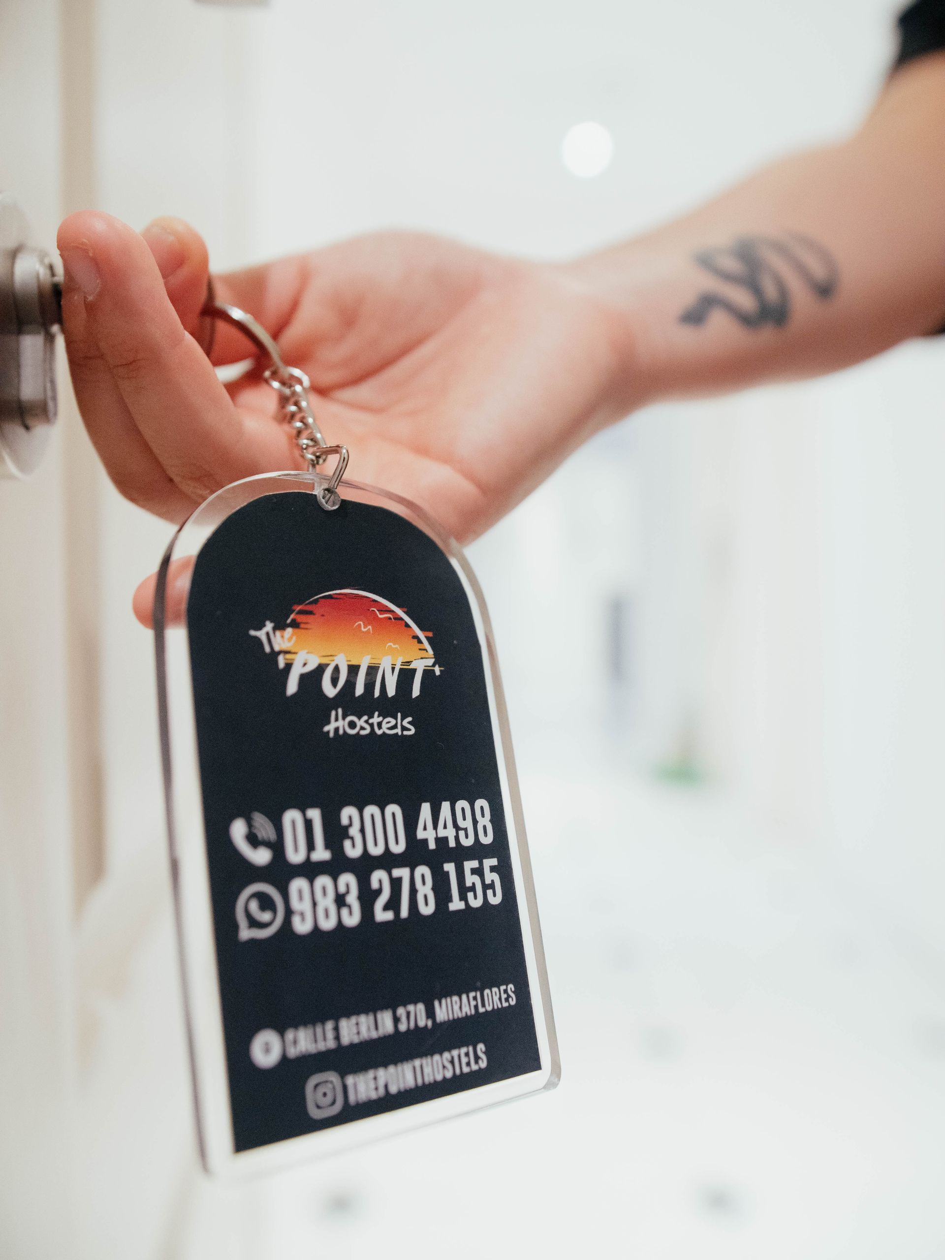 A person is holding a keychain that says point hotel