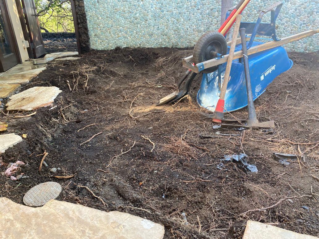 A wheelbarrow is sitting on top of a pile of dirt showing a excavation project. 