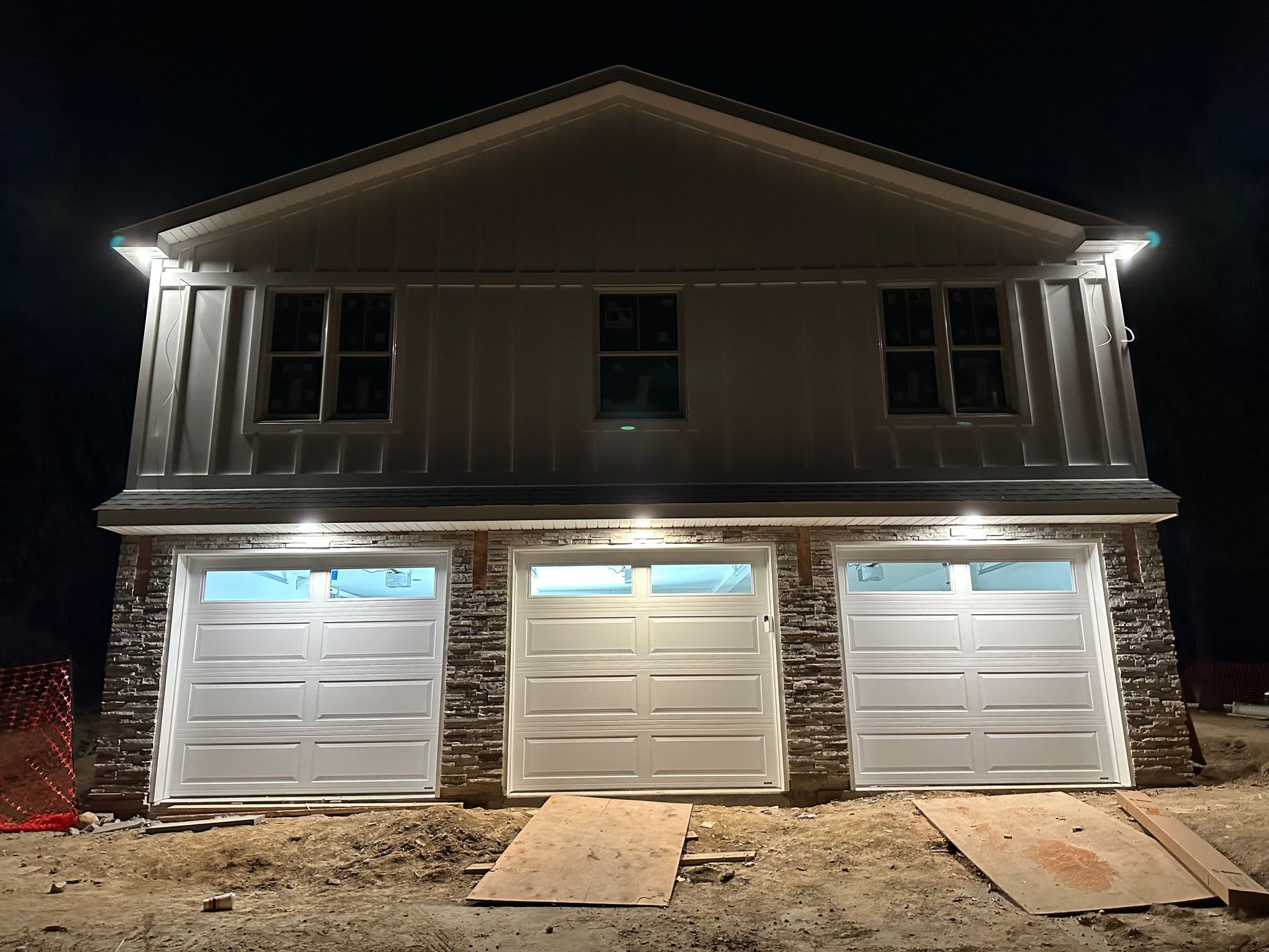 Garage door opener mounted on ceiling with red pull cord and open tracks above a white garage door