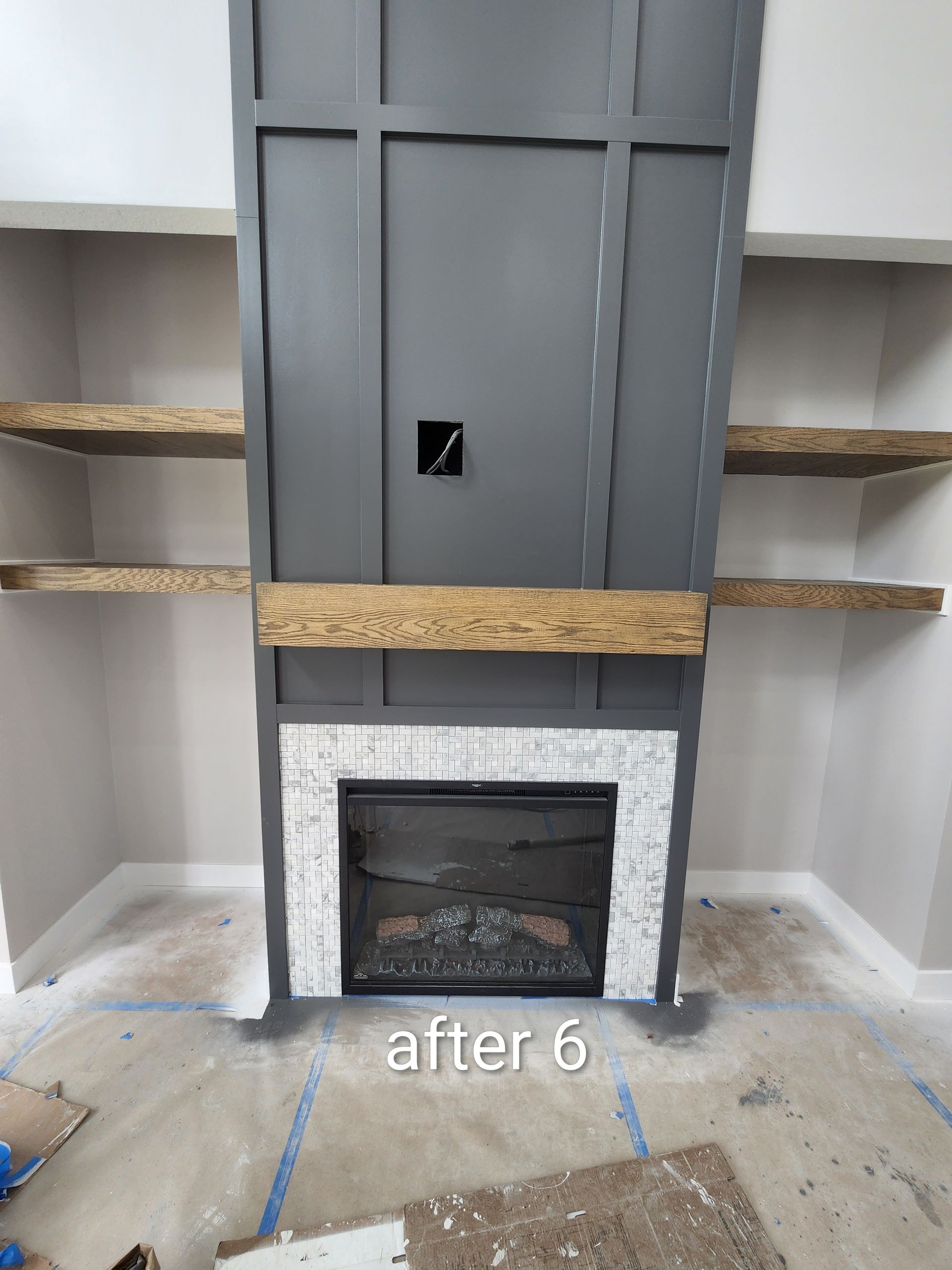 Gray built-in fireplace with unfinished shelving and wood floor, labeled “after 6” at the bottom.