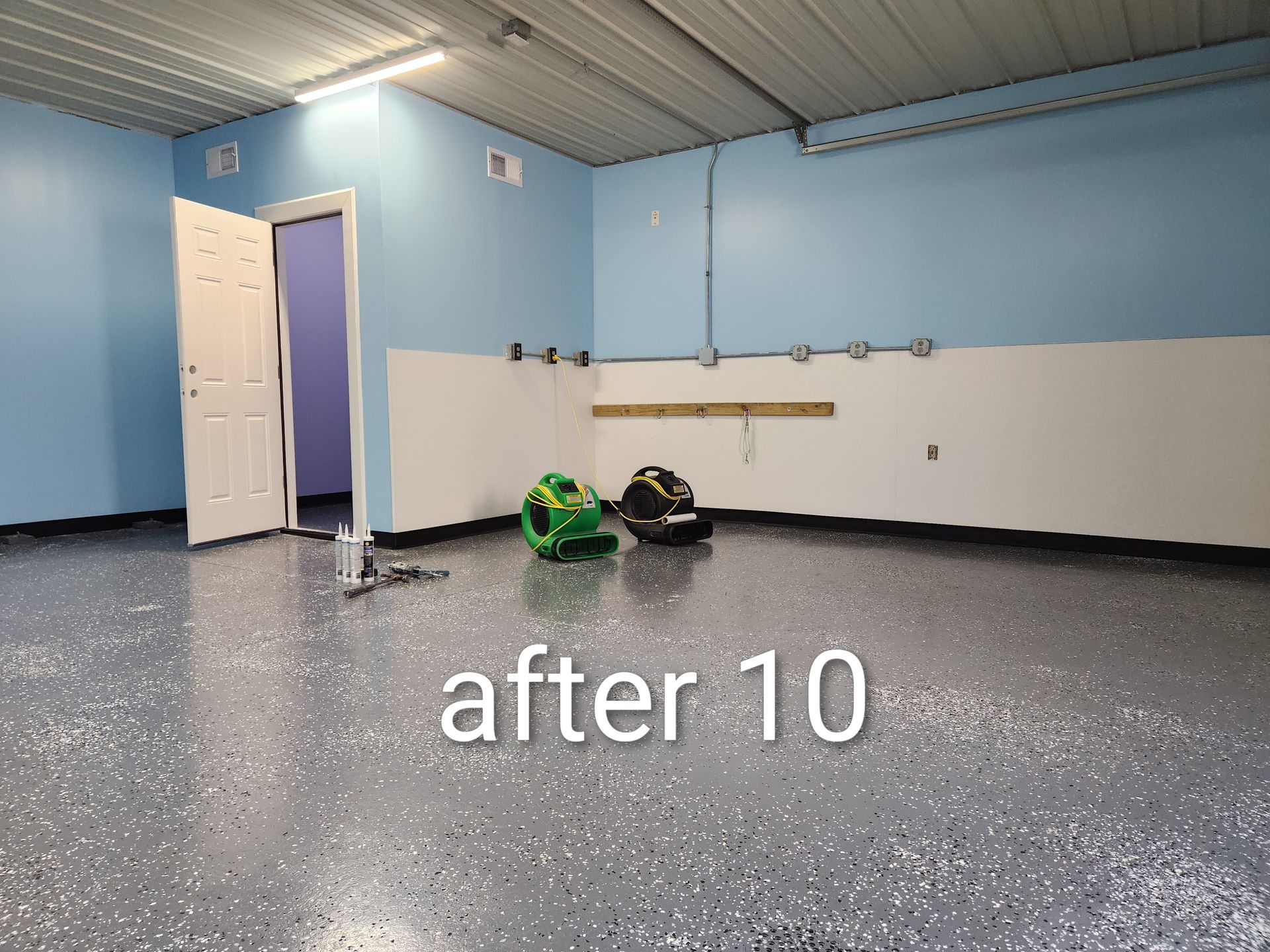 Empty blue room with speckled gray floor, open door, and a small green object on the floor.