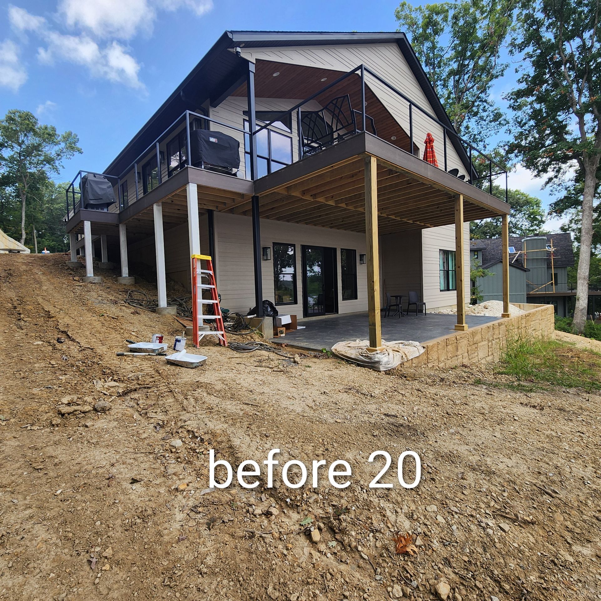Partially built house on a dirt slope with a raised deck and support posts