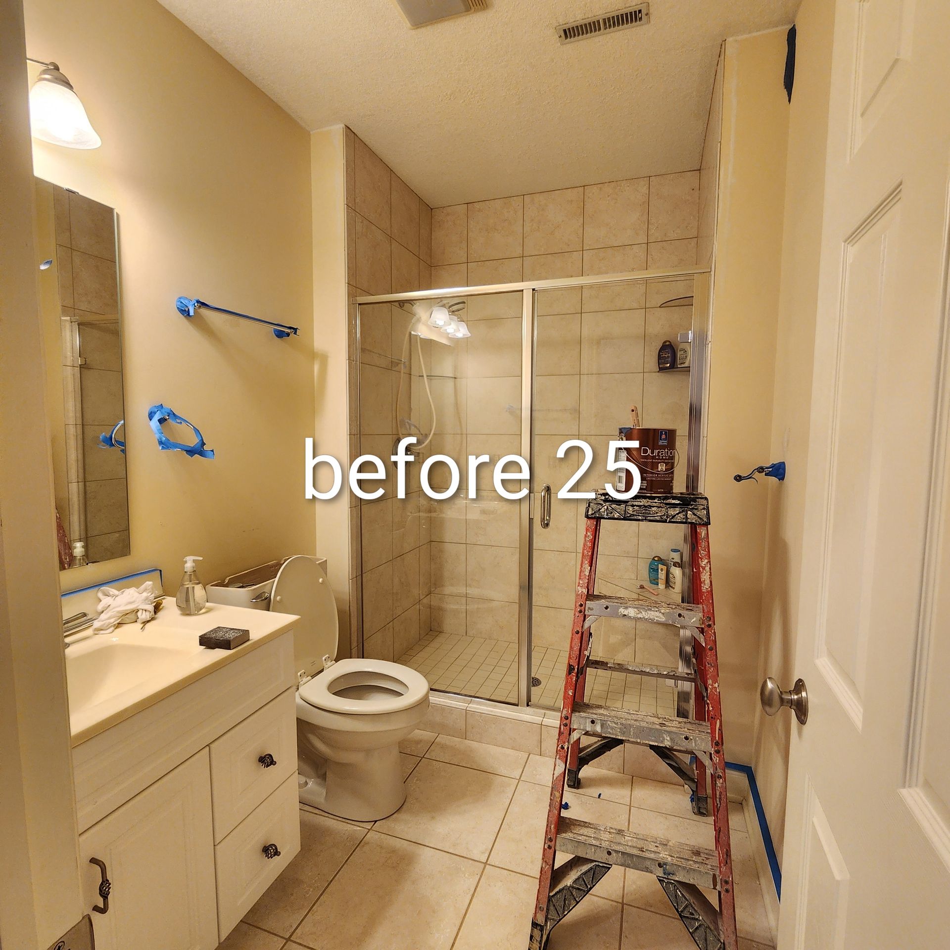 Small bathroom mid-renovation with ladder, exposed shower walls, and a vanity on the left.