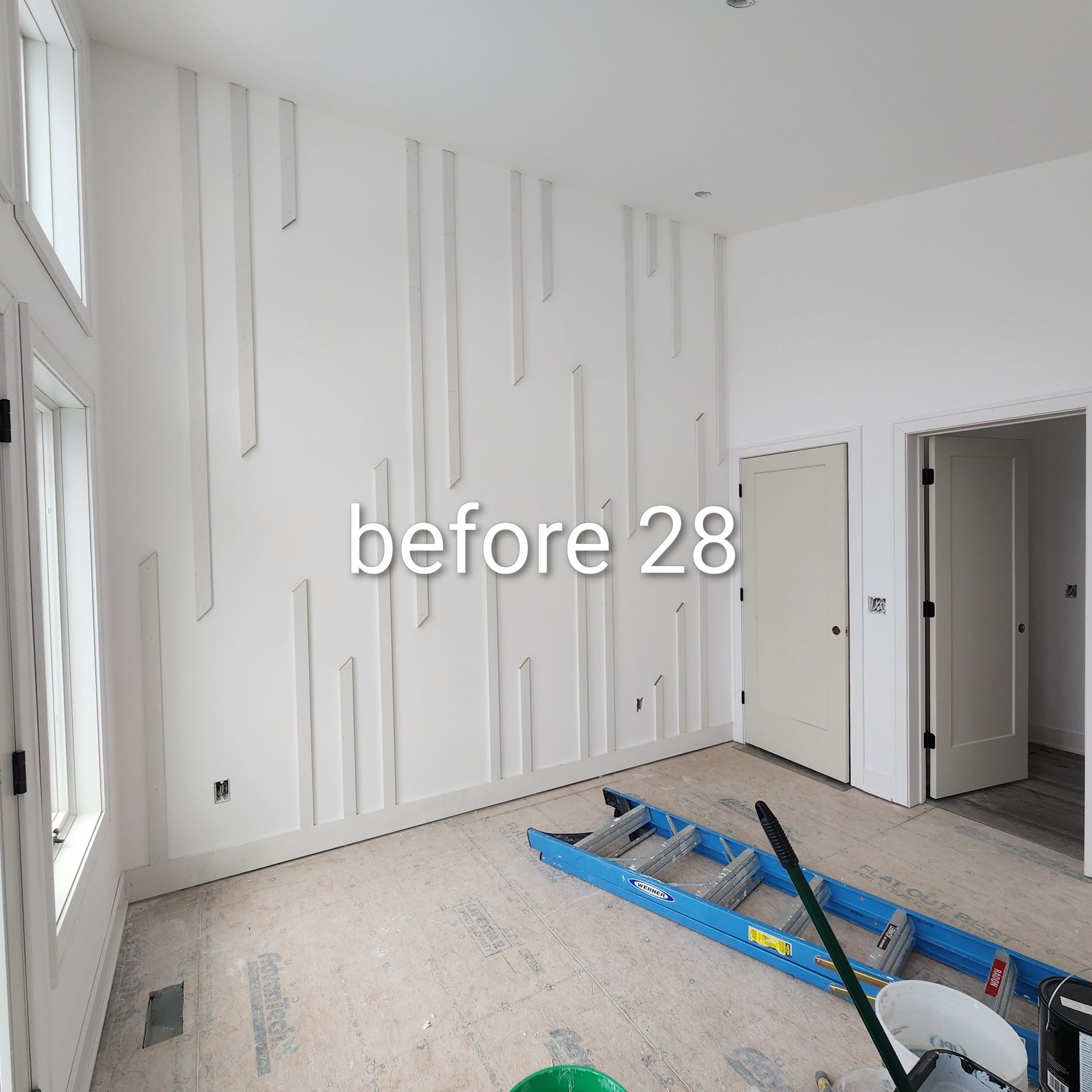White room under renovation with tall wall slats, open door, and blue floor equipment