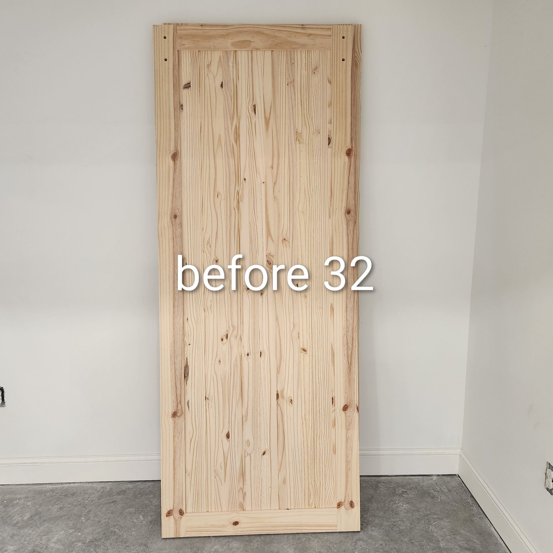 Unfinished wooden door panel leaning against a white wall in a room with carpet.