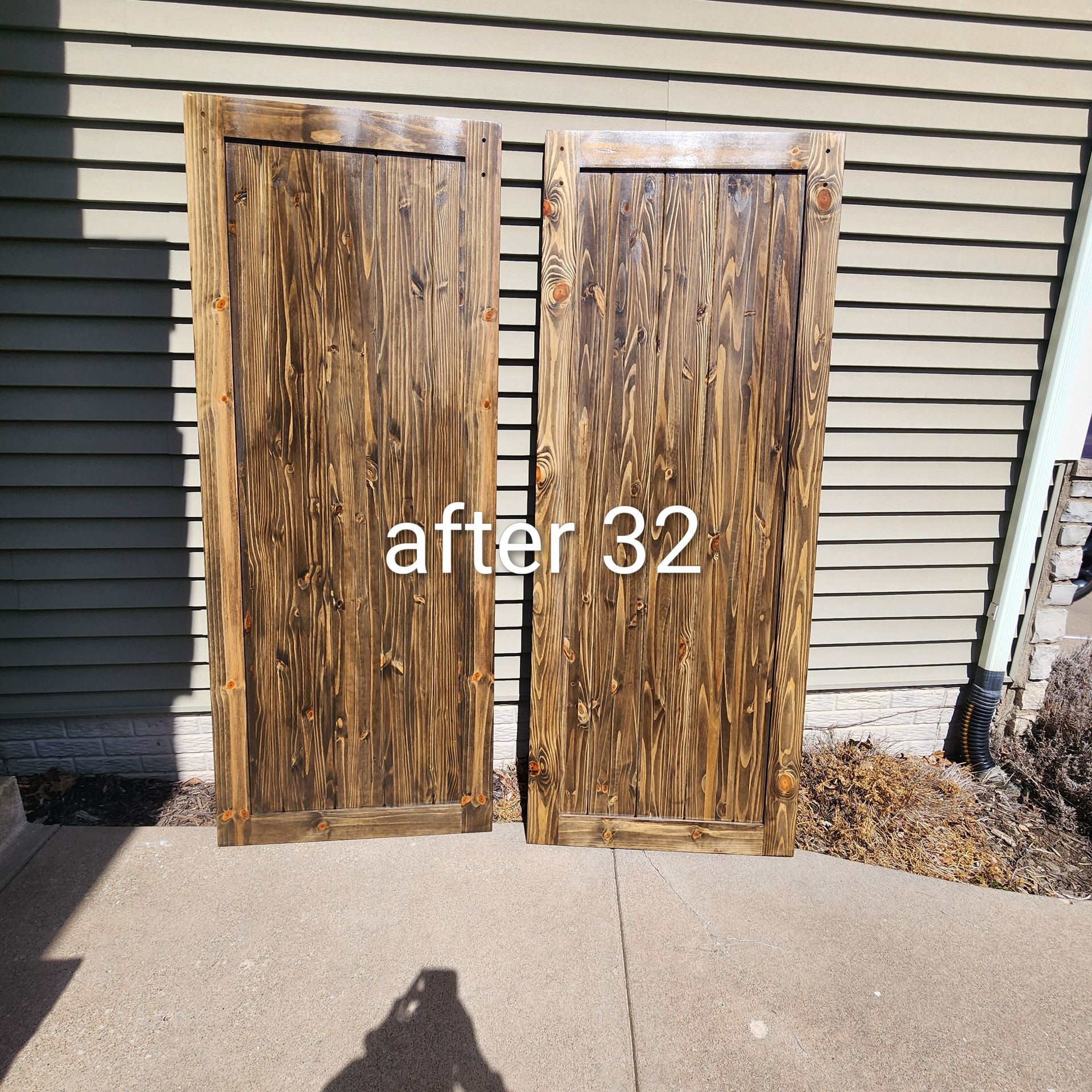 Two weathered wooden doors leaning against a house wall, with “after 32” text overlaid.