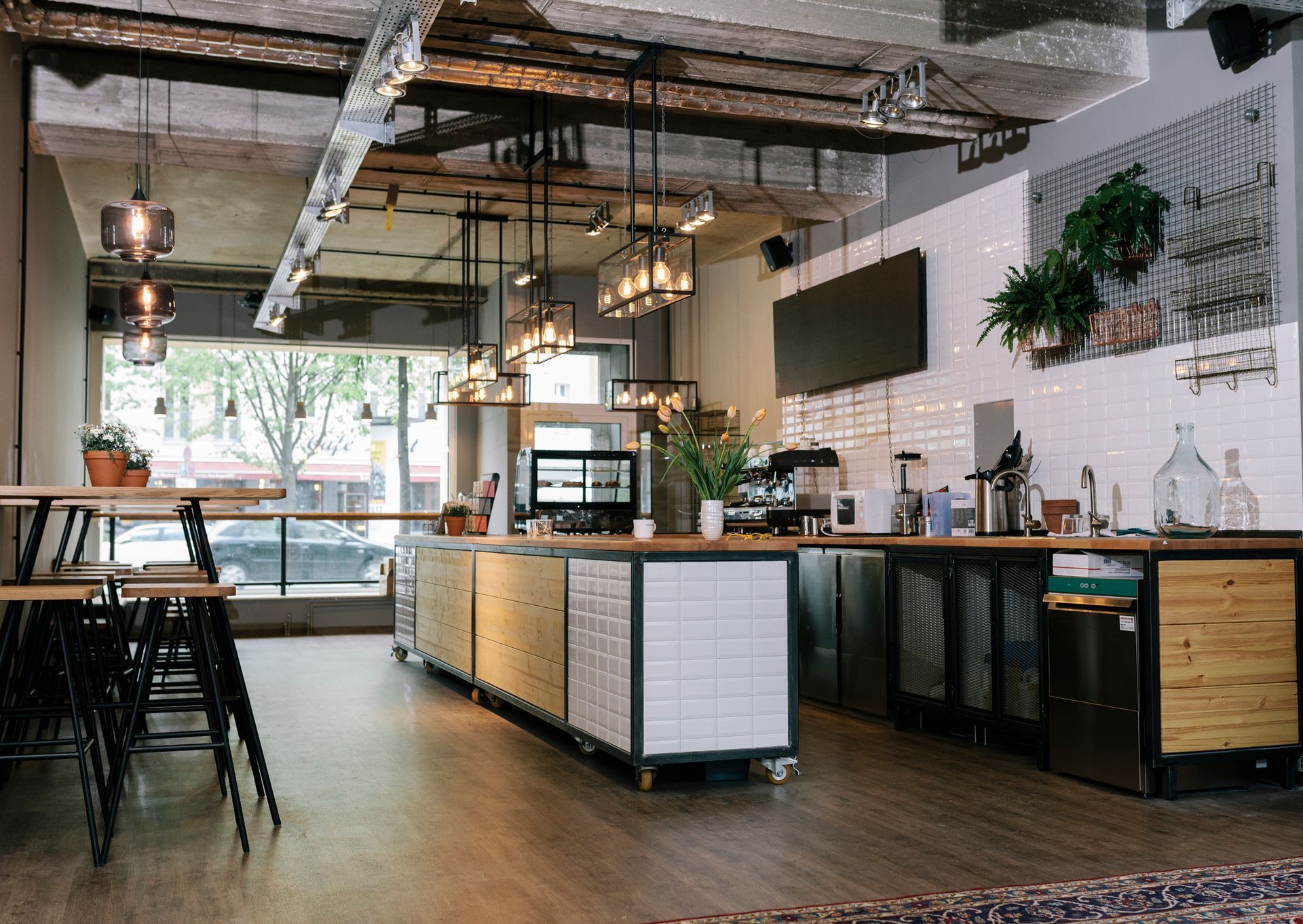 The inside of a restaurant with tables and chairs and a long counter.