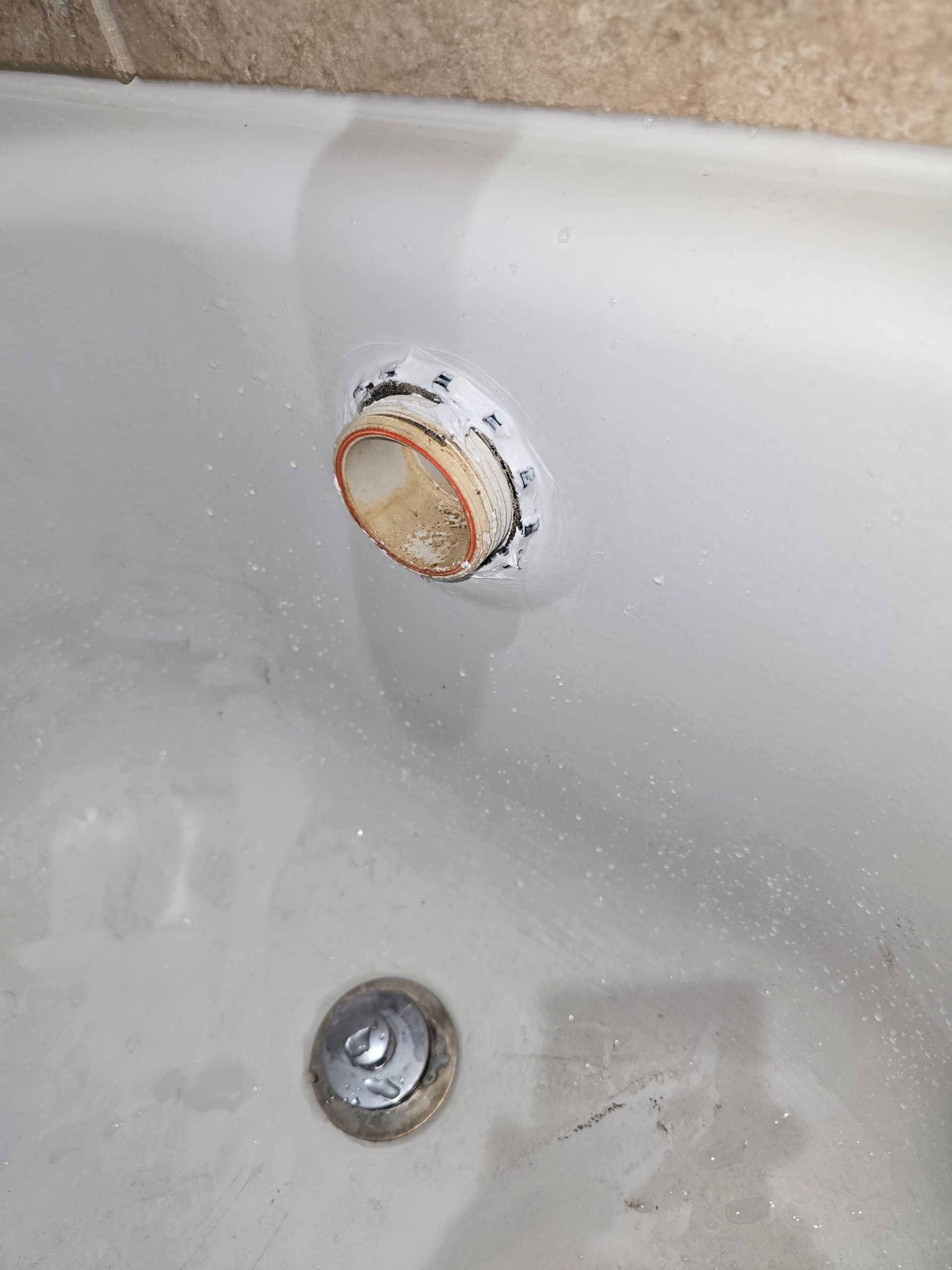 White bathtub with dirty drain and overflow drain.