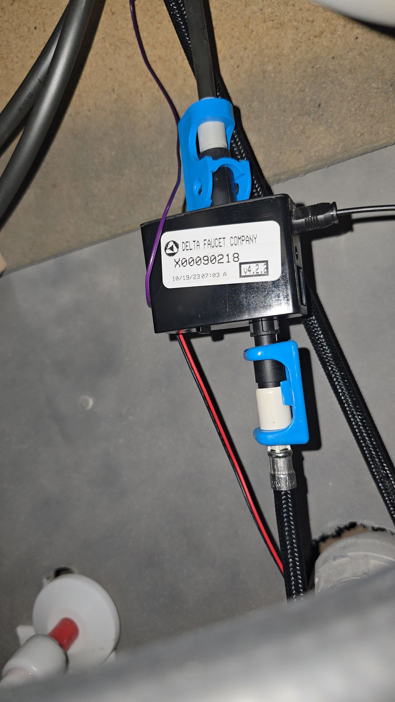 Electrical box with connected wires and coaxial cables, secured by blue clips.