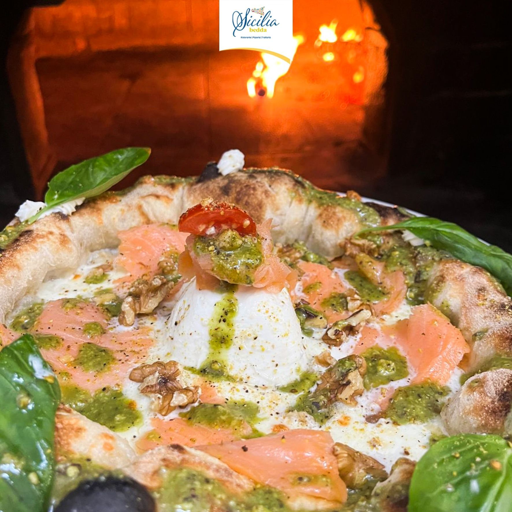 Pizza cotta nel forno a legna con salmone, erbe aromatiche e salsa verde.