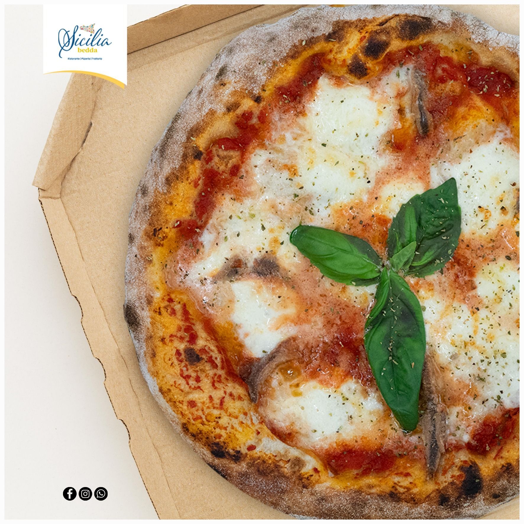 Pizza Margherita in una scatola di cartone, guarnita con foglie di basilico