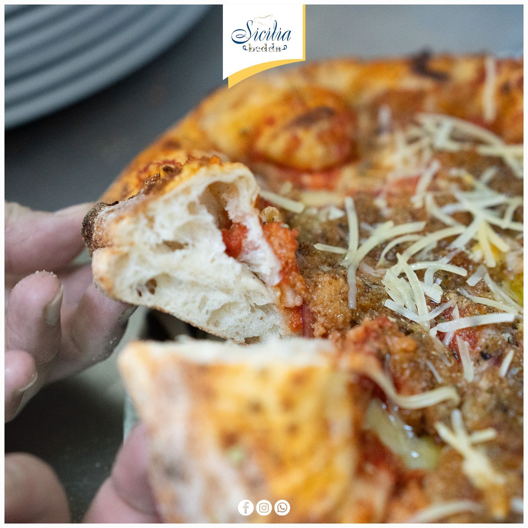 Mano che tiene una fetta di pizza filante con salsa di pomodoro ed erbe aromatiche, primo piano