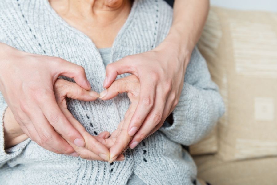 two people holding hands in a heart shape