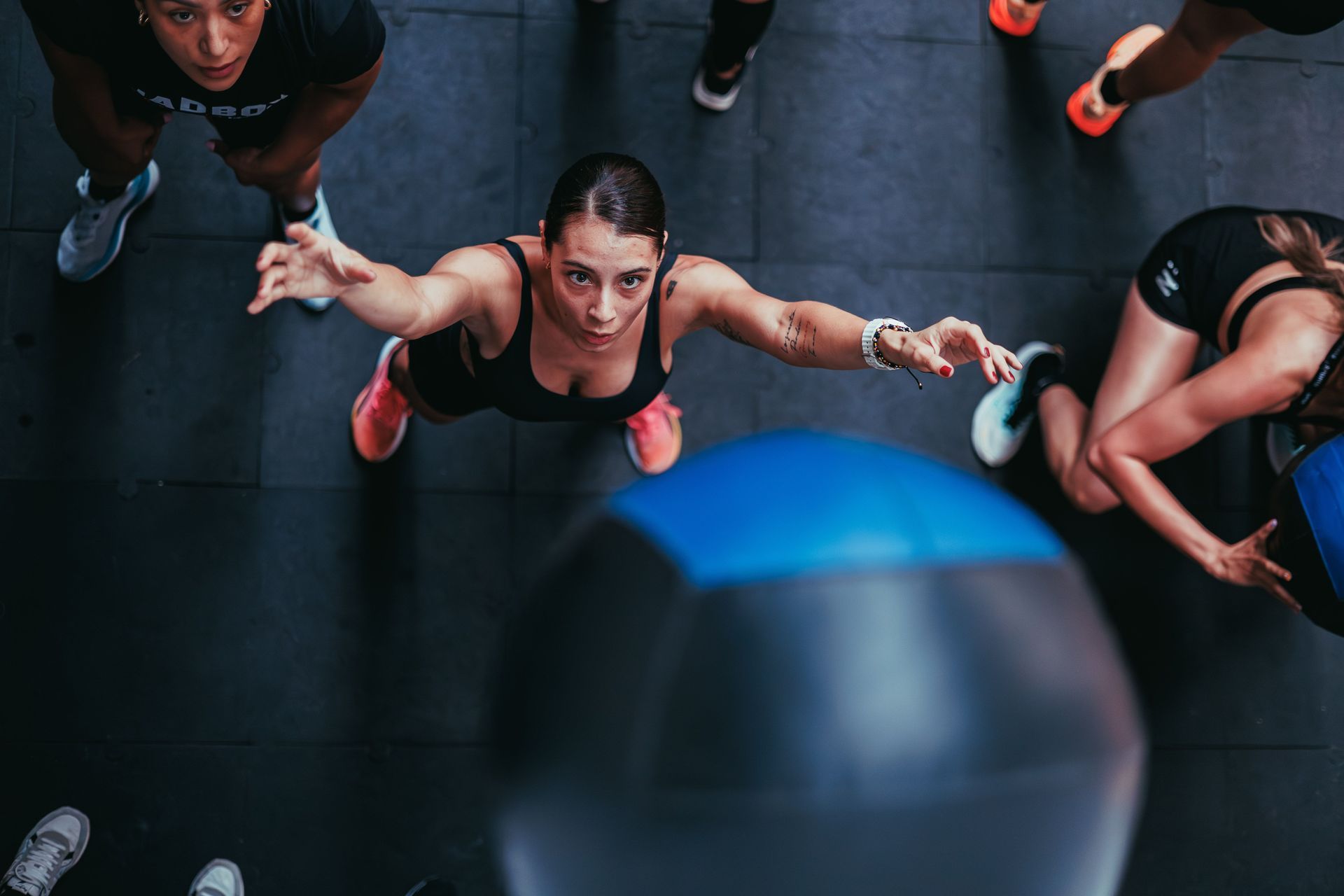 People reaching up toward a medicine ball during a gym workout
