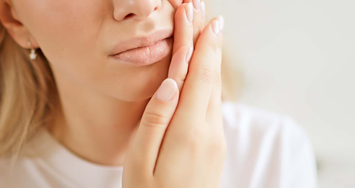 Patient experiencing tooth pain being evaluated by dentist in Babylon NY